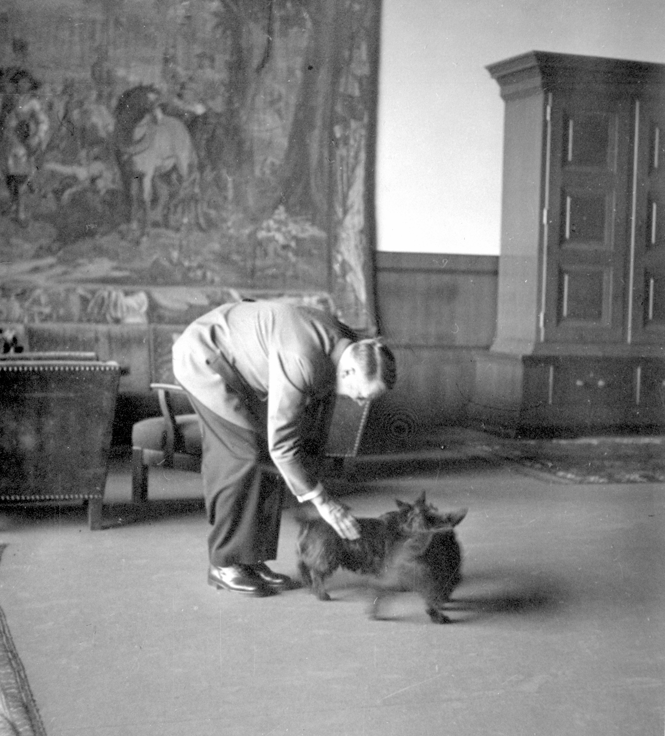 Adolf Hitler petting Eva Braun's dogs in the Berghof great hall, from Eva Braun's albums 